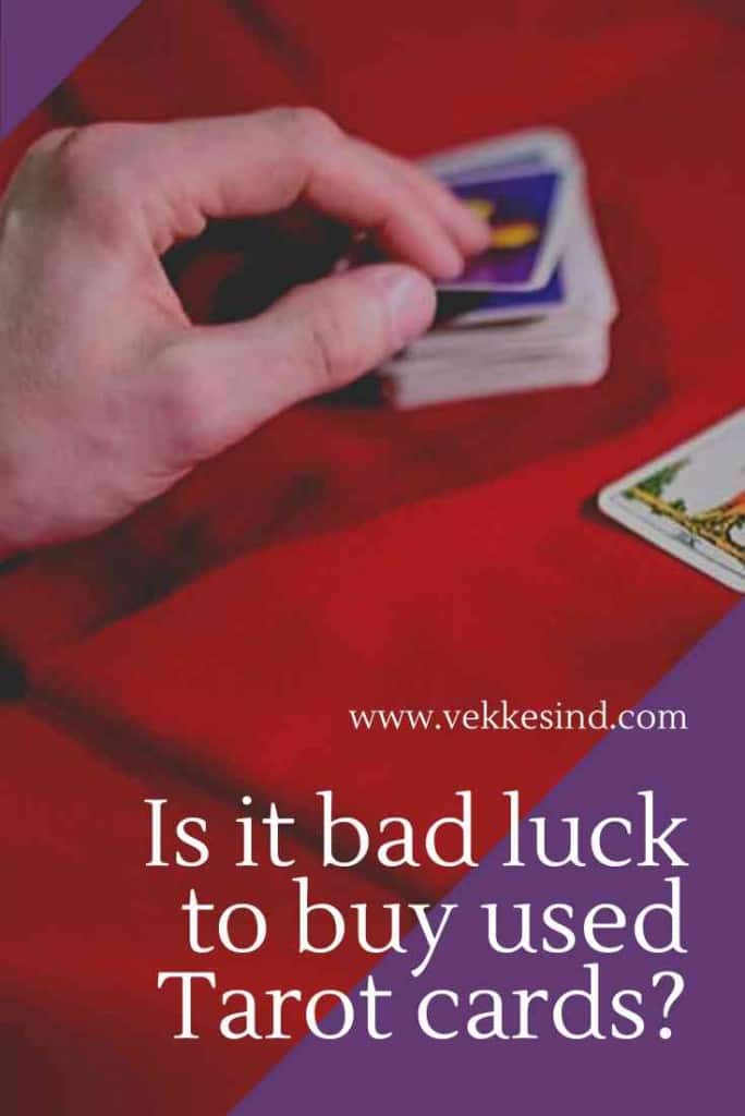 A collection of tarot cards spread across a wooden surface, different decks showing varied artistic styles