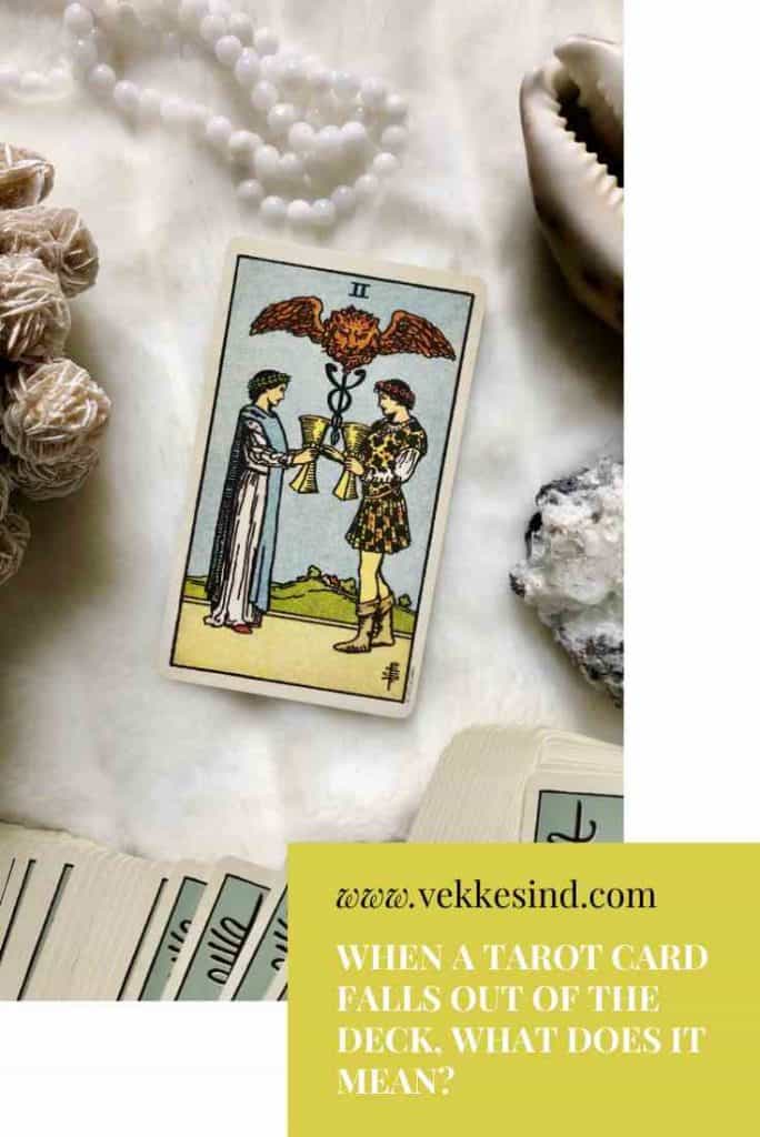 Hands carefully handling a tarot deck, fingers spread over the cards in a slow shuffle
