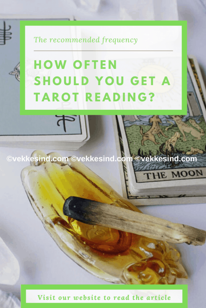 Tarot cards laid out on a table with candles and a journal nearby, suggesting a thoughtful personal practice