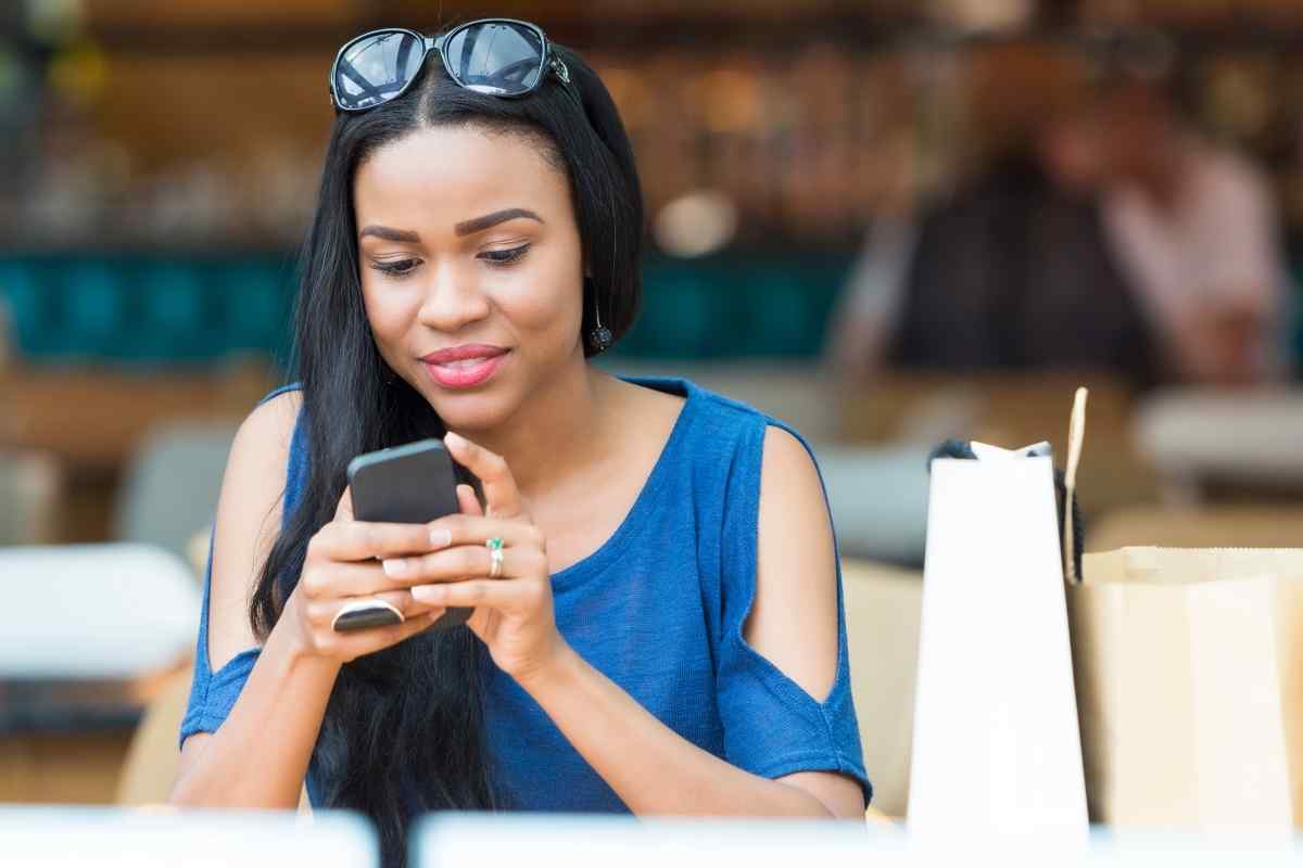 Woman reading a message on her phone with an amused, thoughtful expression