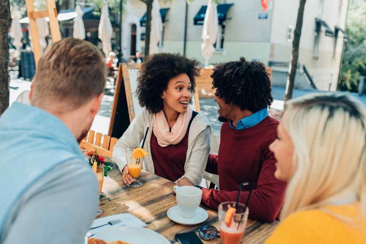 A man and woman talking easily among friends at a relaxed social gathering