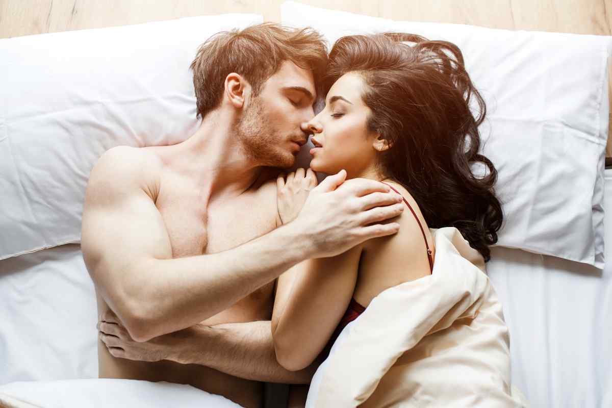 A couple sharing slow, tender physical affection that communicates genuine desire