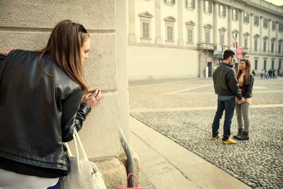 A couple standing far apart on a pathway, both facing opposite directions, representing the thorough separation a Scorpio woman creates when she has moved on