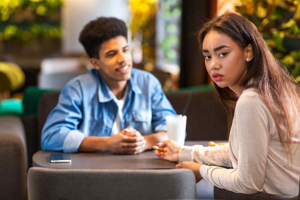 A woman fully engaged with her laptop in a coffee shop, clearly absorbed in her own world, representing an Aquarius woman redirecting her energy and moving forward