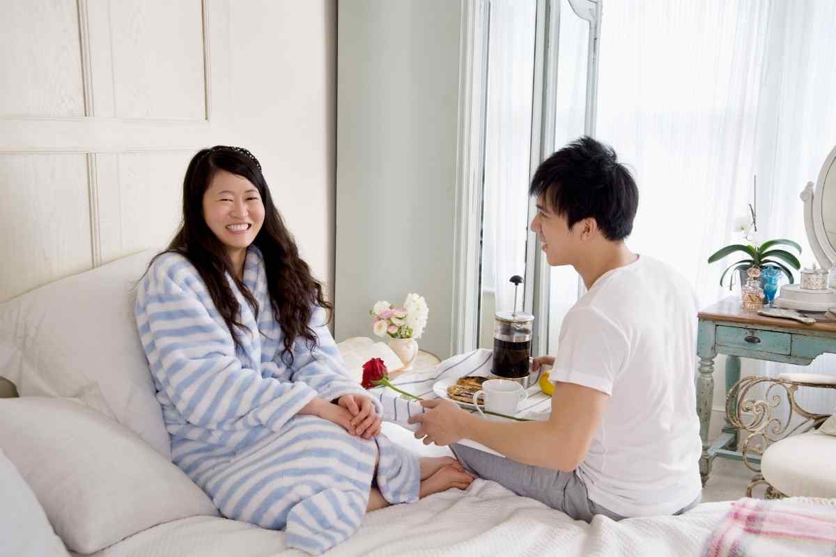 A couple in a soft, romantic setting with warmth and physical closeness