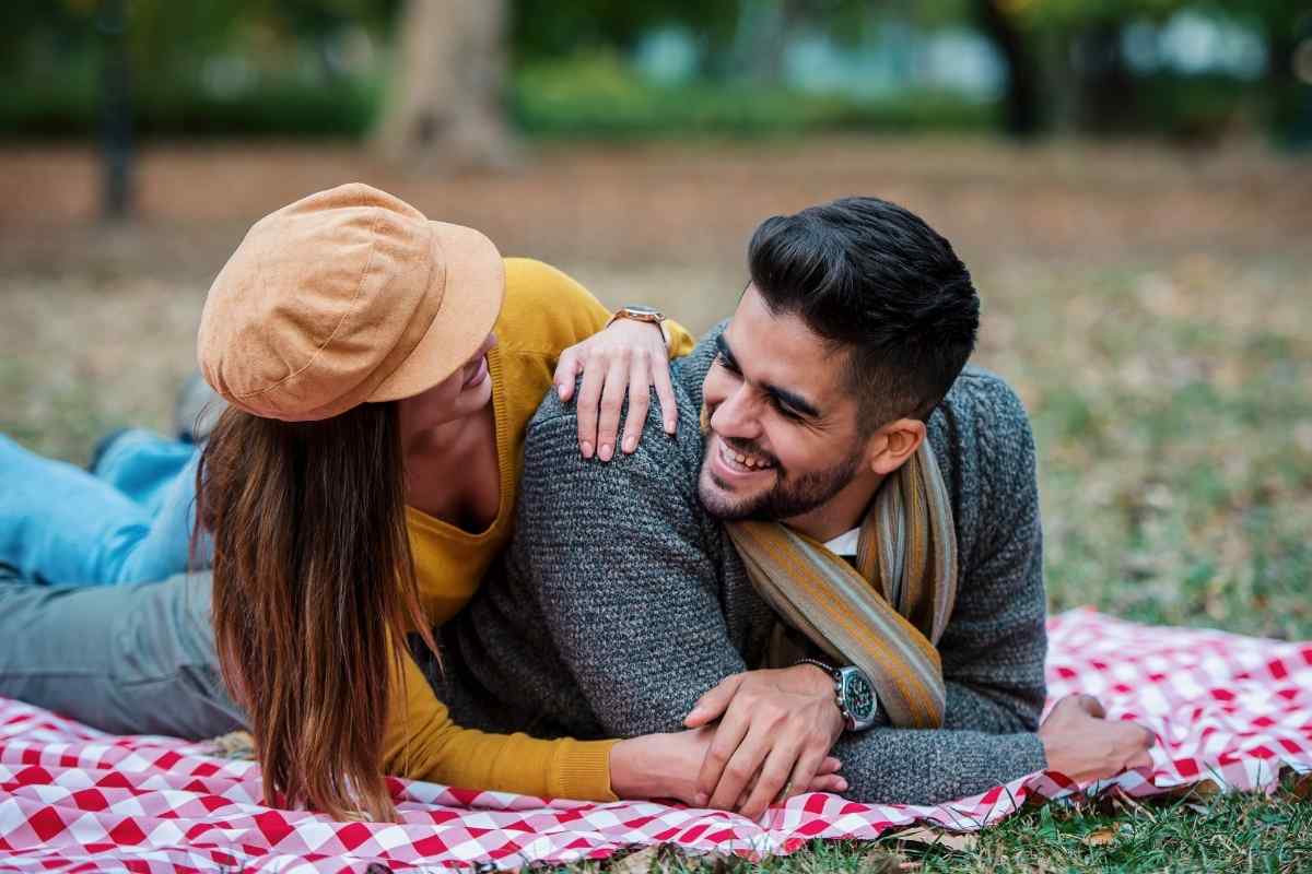 A warm, laughing woman touching someone's arm during a lively conversation, capturing the natural physical warmth of a Sagittarius woman's flirting style