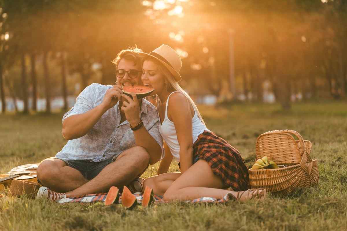 A bright, animated woman leaning toward someone during an outdoor conversation, reflecting the Sagittarius woman's genuine, warm enthusiasm when she is interested