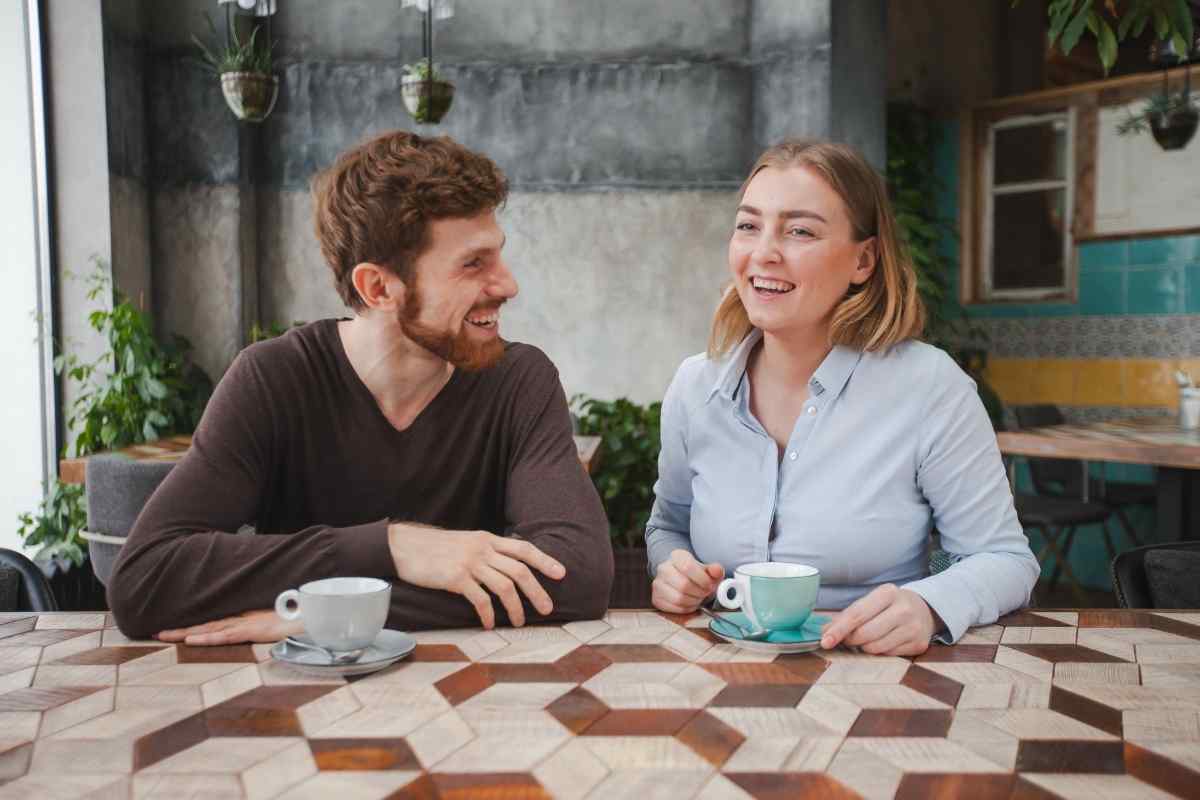 A woman in conversation, leaning in with genuine interest and her full attention on one person