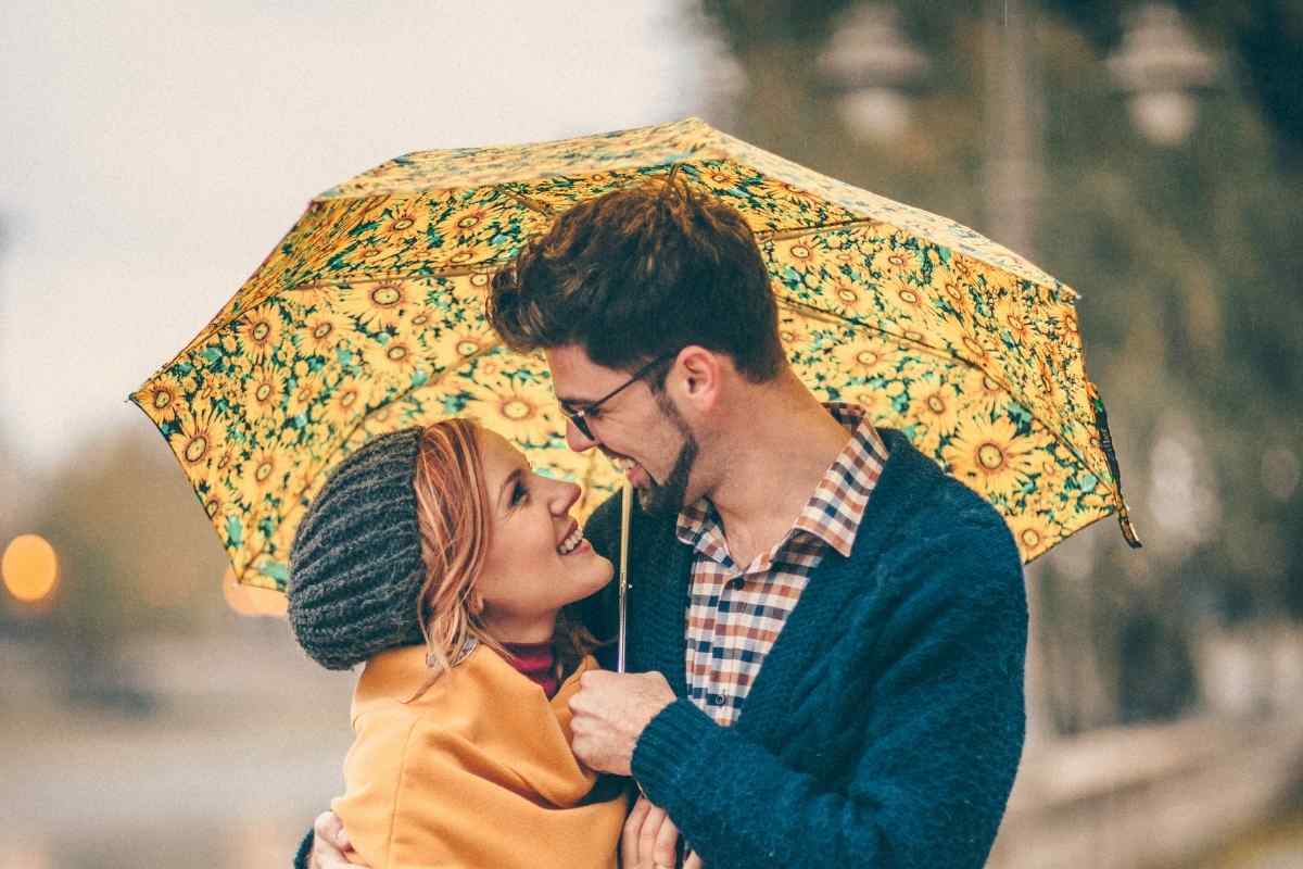 An Aries man and woman walking together, his posture attentive and slightly protective, both engaged in easy conversation