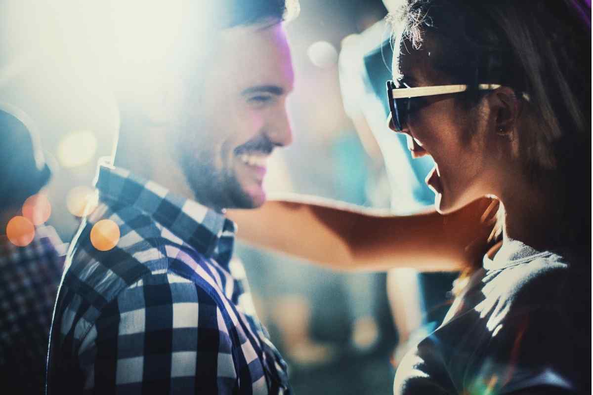 Woman looking at her phone while emotionally distant from her partner, illustrating the signs of withdrawal in a Sagittarius woman who has disengaged from a relationship