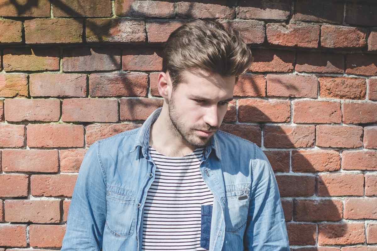 Aquarius man looking thoughtful and distant by a window