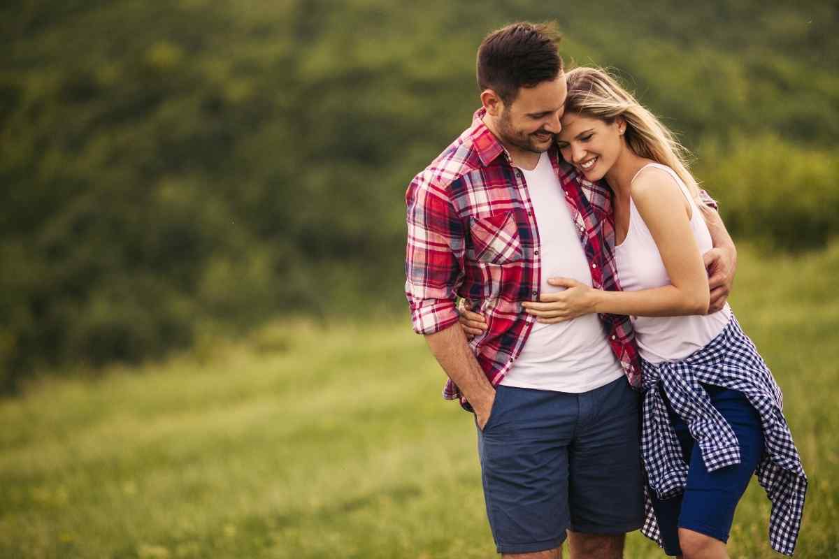 Two people laughing together outdoors in warm light, reflecting the Libra man and Sagittarius woman's shared love of good conversation, adventure, and genuine fun