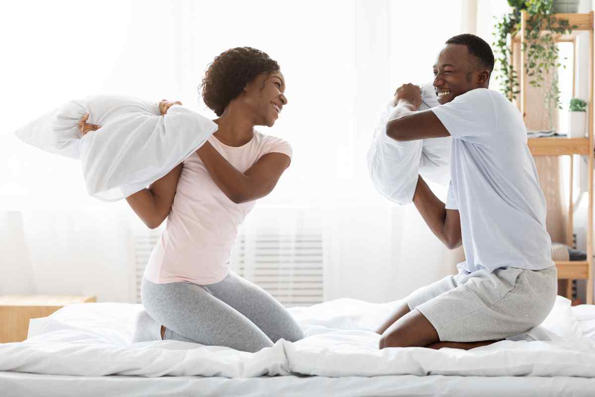 A couple in a relaxed, intimate setting, hands gently held together in a moment of warmth