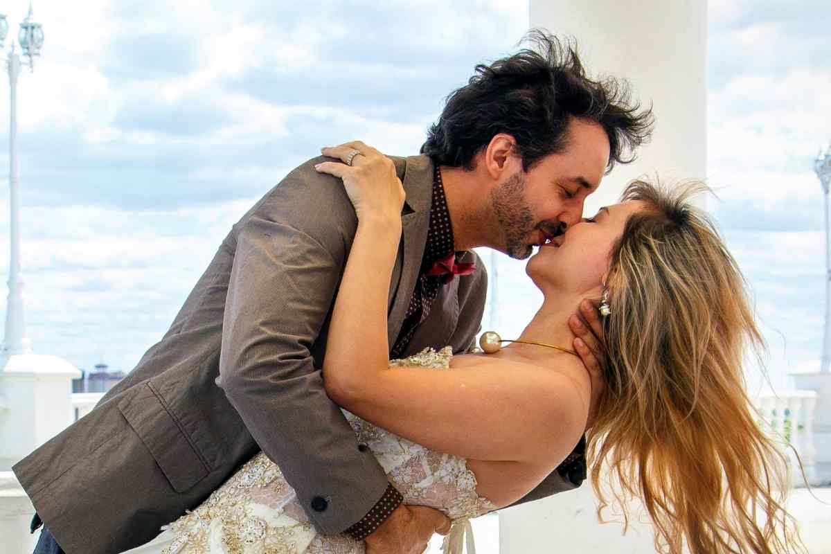 A couple sharing a relaxed, close moment, one partner gently running fingers through the other's hair