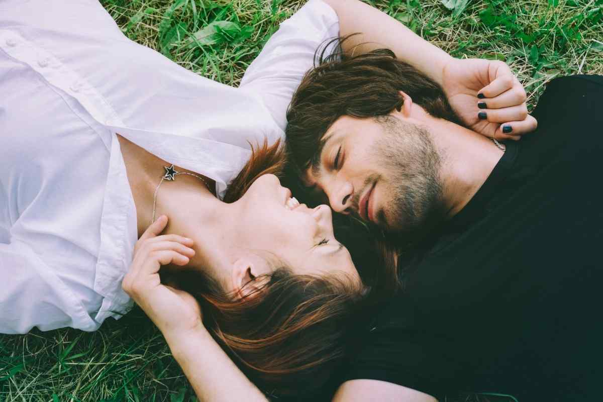 Couple in an intimate moment, woman's fingers in her partner's hair while he leans in close