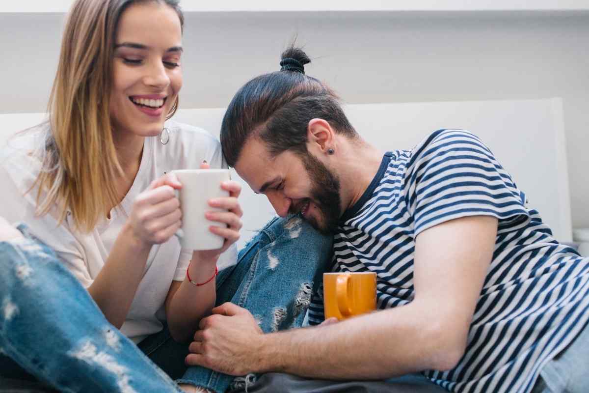 A couple in a calm, warm setting, the woman gently touching the man's arm