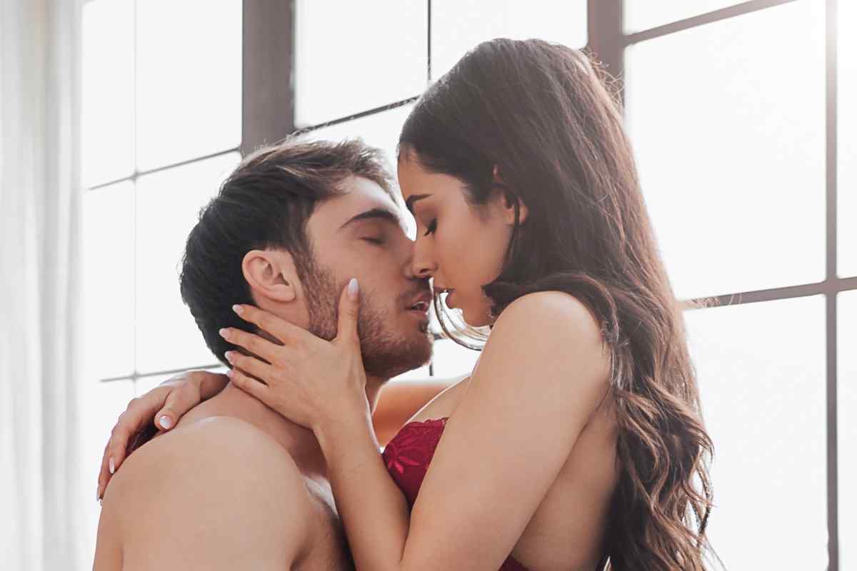 A couple in relaxed, natural surroundings sharing a spontaneous, warm physical moment