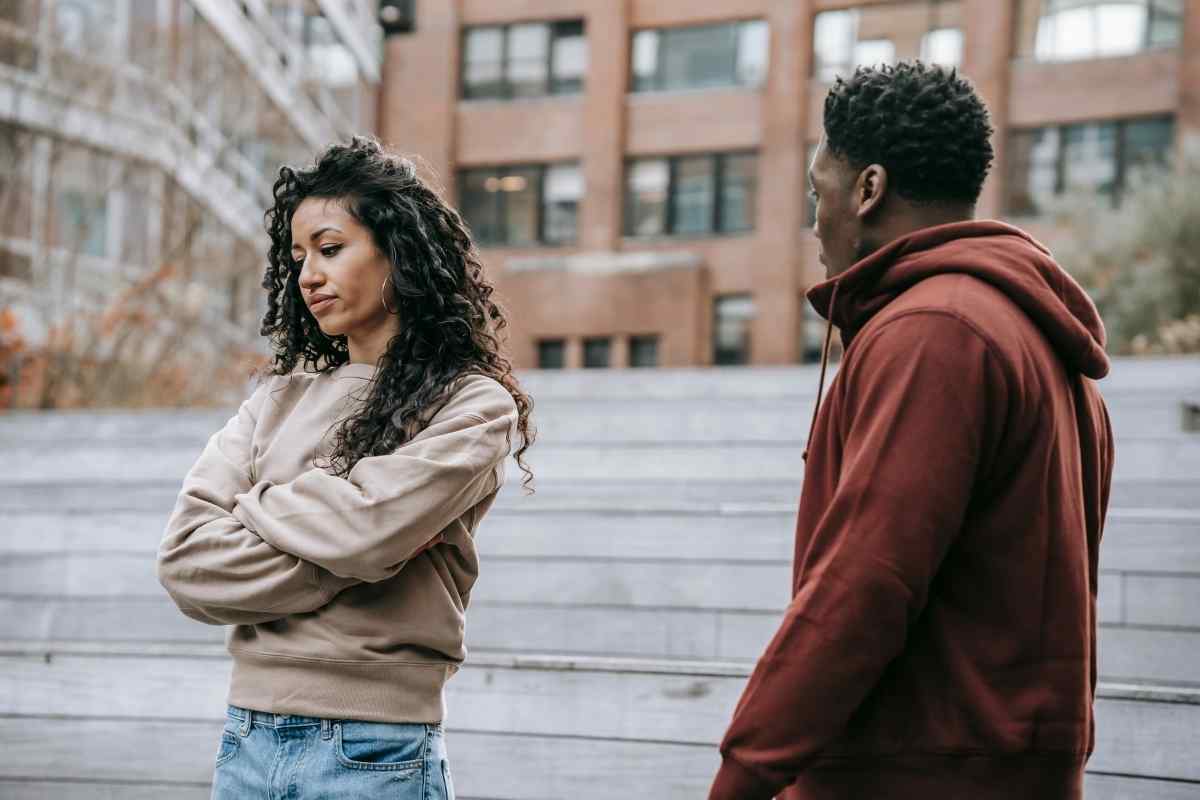 A couple with visible tension between them, the woman looking in a different direction with a distracted expression