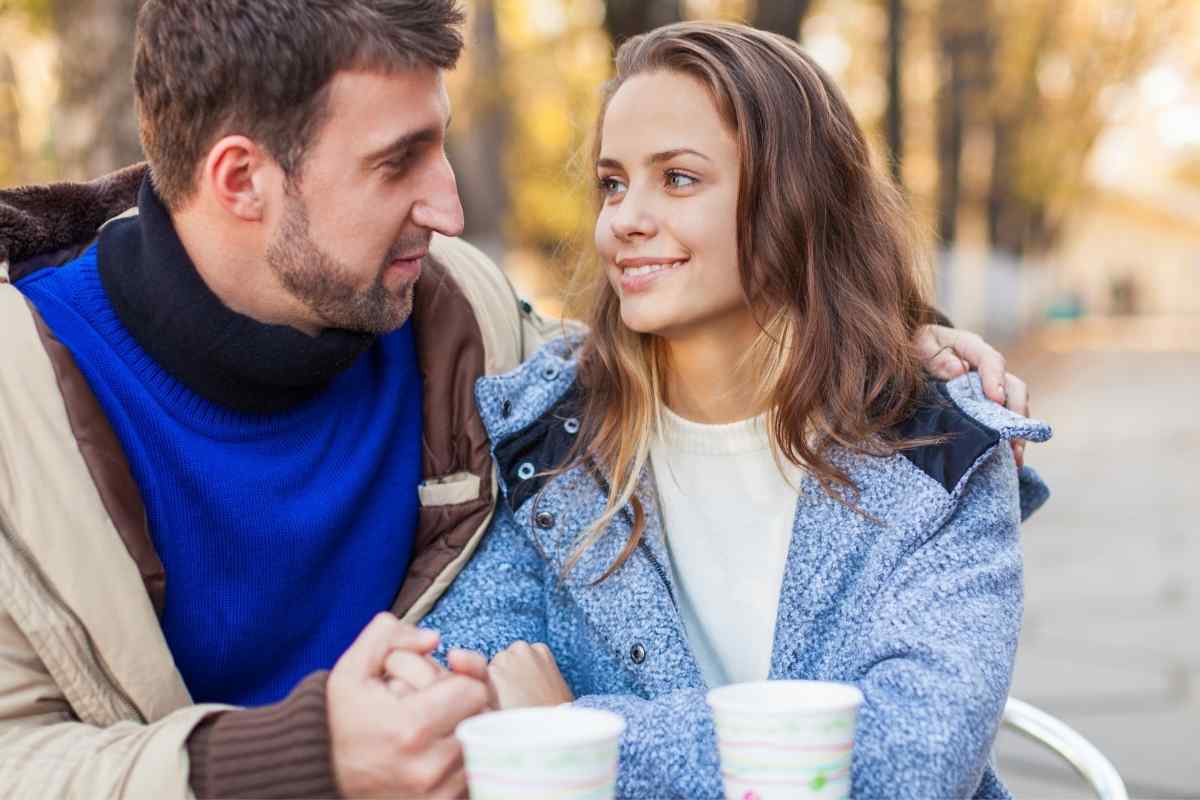 Two people talking at a table with warm but honest body language, each fully present in the conversation