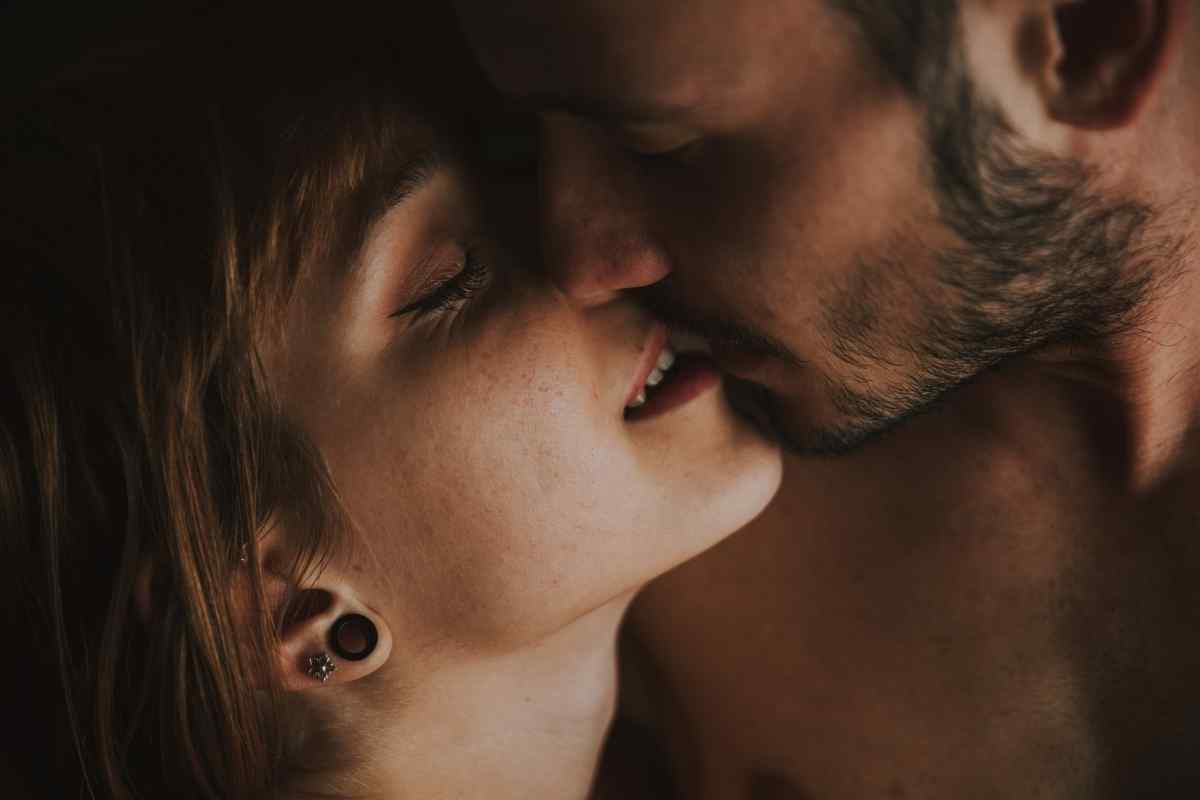 A confident woman with warm eyes leaning in close, lit by golden afternoon light