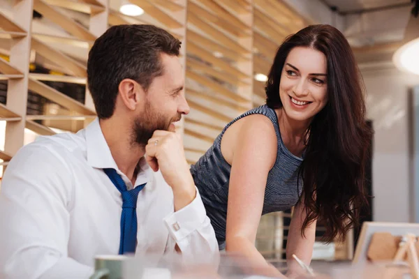 Leo woman leaning toward a man with warm, focused attention and a bright expression
