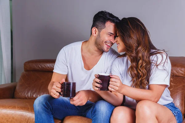 A woman laughing openly and leaning toward a man in relaxed, easy conversation at a coffee shop